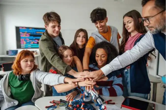 Diverse team of eight people with hands together in a huddle, celebrating unity and growth.