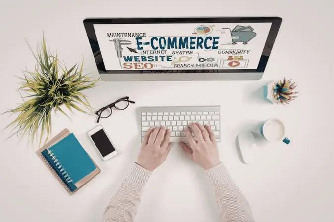 Overhead view of hands typing at laptop with e-commerce