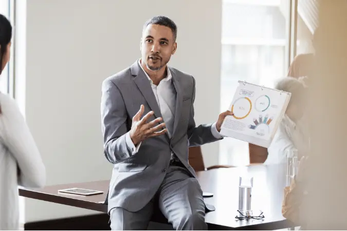 Sales professional confidently demonstrating a technique on a whiteboard