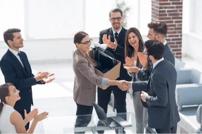 Diverse team of six professionals congratulating a new employee
