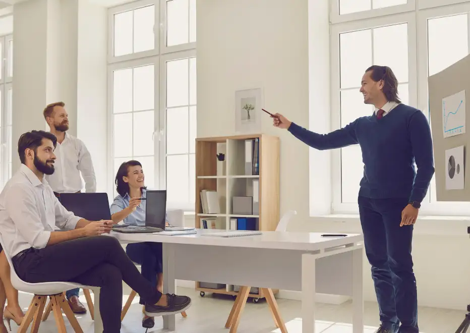Team leader presenting to colleagues in a bright office.