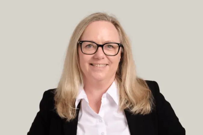 Portrait of a smiling woman in a blazer, for CMI Level 7 Management & Leadership.