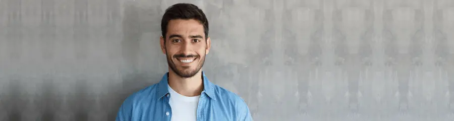 Smiling man in a denim shirt, portrait for individuals progressing their career.
