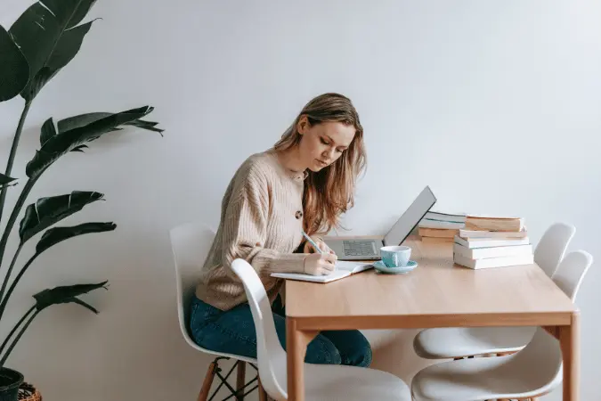 Professional studying sales with a laptop and notebook